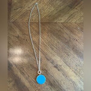 Turquoise pendant on gold chain.